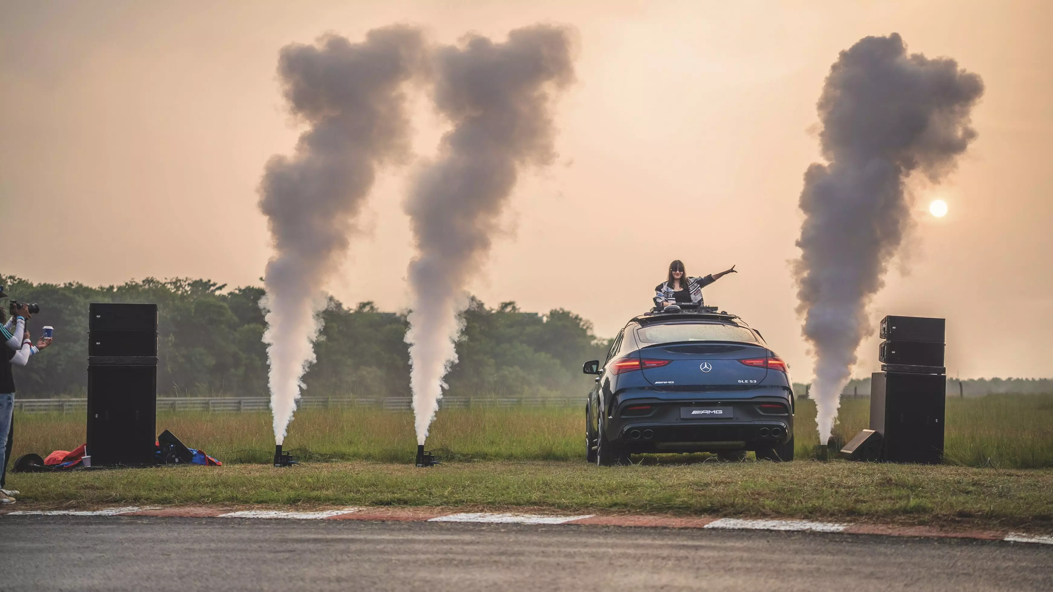 A Mercedes-AMG GLE 53 with a DJ popping out of the sunroof at turn 9 of the Madras International Circuit